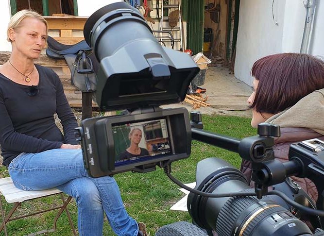 Filmkamera mit Moderatorin und Protagonistin im Freien bei Recruitingfilm